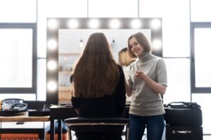 فضای شلوغ سالن زیبایی با چند آرایشگر فعال، نمادی از رقابت داخلی کارکنان